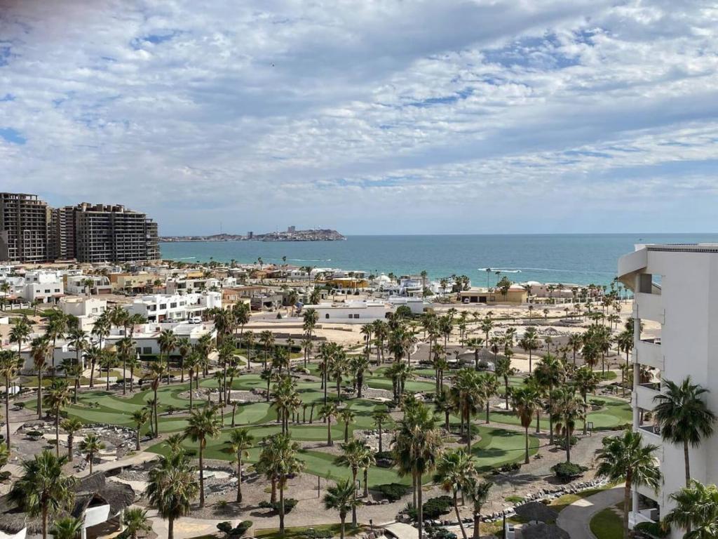 uma vista para um resort com palmeiras e o oceano em Lovely 2-Bedroom Pet Friendly Sea View Haven em Puerto Peñasco
