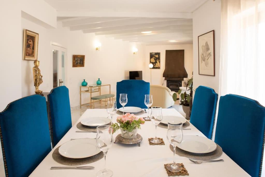 White Star Estoril في استوريل: طاولة مع كراسي زرقاء وطاولة مع كؤوس للنبيذ