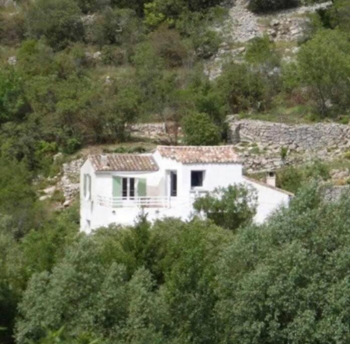 una casa bianca seduta in cima a una collina di L’escapade, coeur de la nature a Saint-Hippolyte-du-Fort