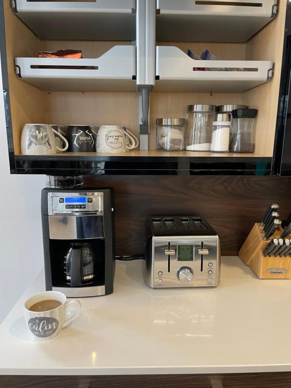 eine Küche mit zwei Mikrowellen und einer Kaffeemaschine in der Unterkunft Le Jarret Noir! Chalet NEUF en nature SPA/Vue Lac in Pohénégamook