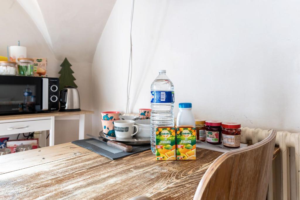 a table with a bottle of water and food on it at Bed end breakfast du centre in Bourg-Saint-Maurice