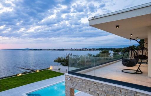 una casa con piscina e vista sull'acqua di Luxurious beachfront Villa with sea view - by TA Leut Agency a Privlaka (Brevilacqua)