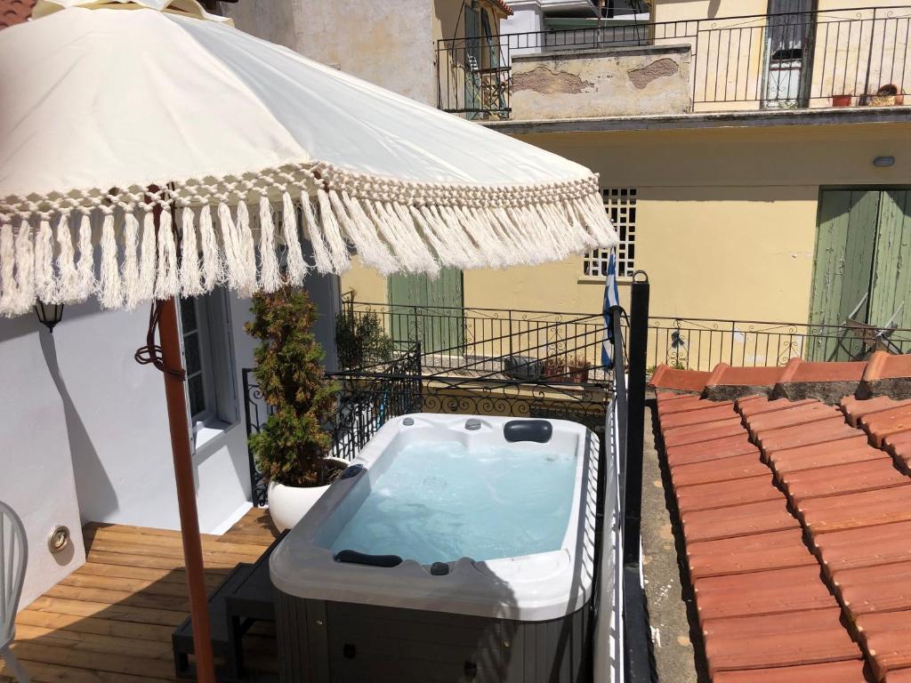bañera de hidromasaje con sombrilla en el balcón en Evagelia's Villas en Skopelos Town