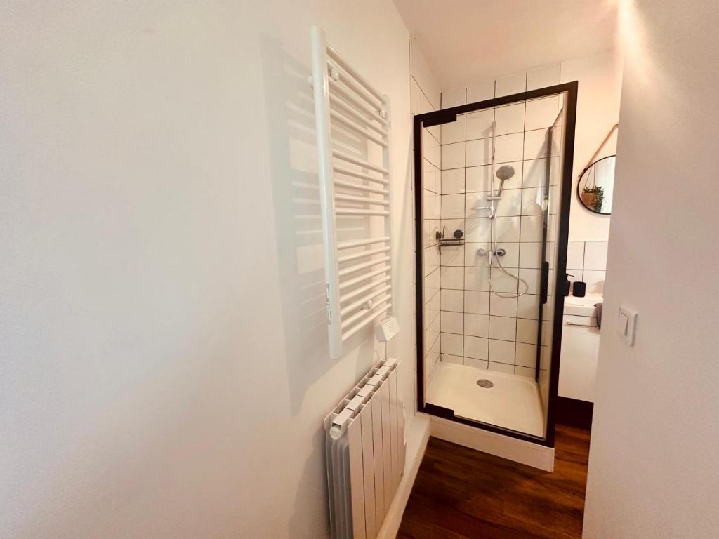 a white bathroom with a shower and a mirror at Pomme d&#39;api - 319 in Rouen