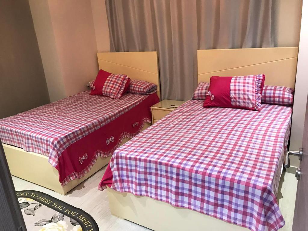 1 Schlafzimmer mit 2 Betten mit roter und weißer Bettwäsche in der Unterkunft Ilmontegalala in Ain Suchna