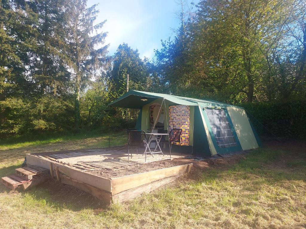 a green tent with a table in a field at Camp marsac in Saint-Thurial