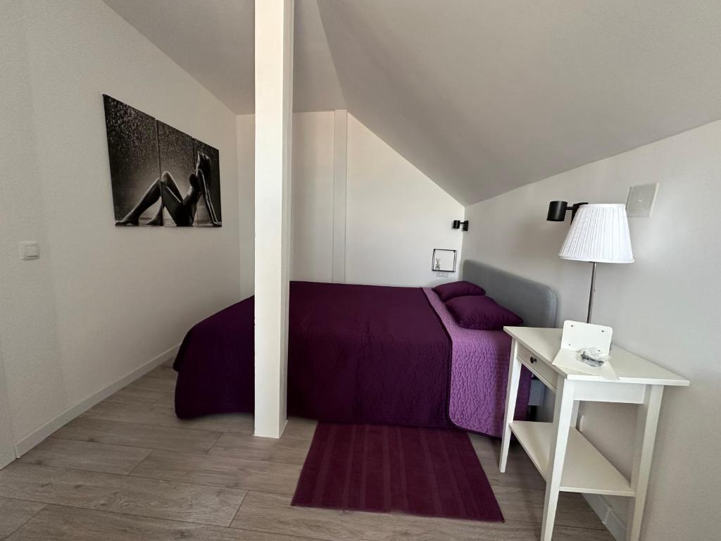 a bedroom with a purple bed and a table at Košava in Golubac
