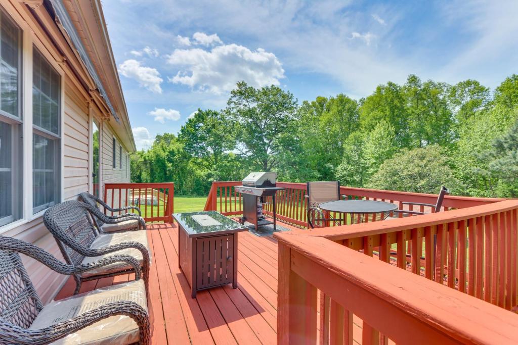 a deck with a grill and chairs and a table at Chatham Getaway with Fireplace, Deck and Gas Grill! in Chatham