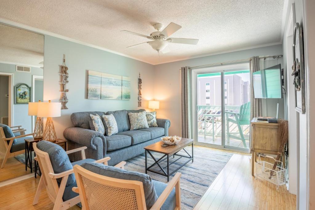 カロライナビーチにある2nd Row Condo with Oceanviews - Haven at TideWindsのソファとテーブルのあるリビングルーム