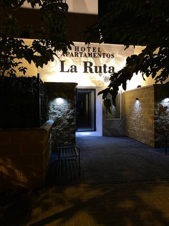 a bench in front of a building with a sign at Apartamentos La Ruta in Calpe