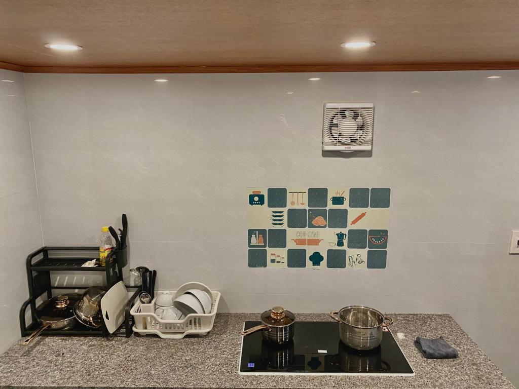a kitchen with a counter with a stove and a wall at Ngất Ngây Homestay in Sầm Sơn