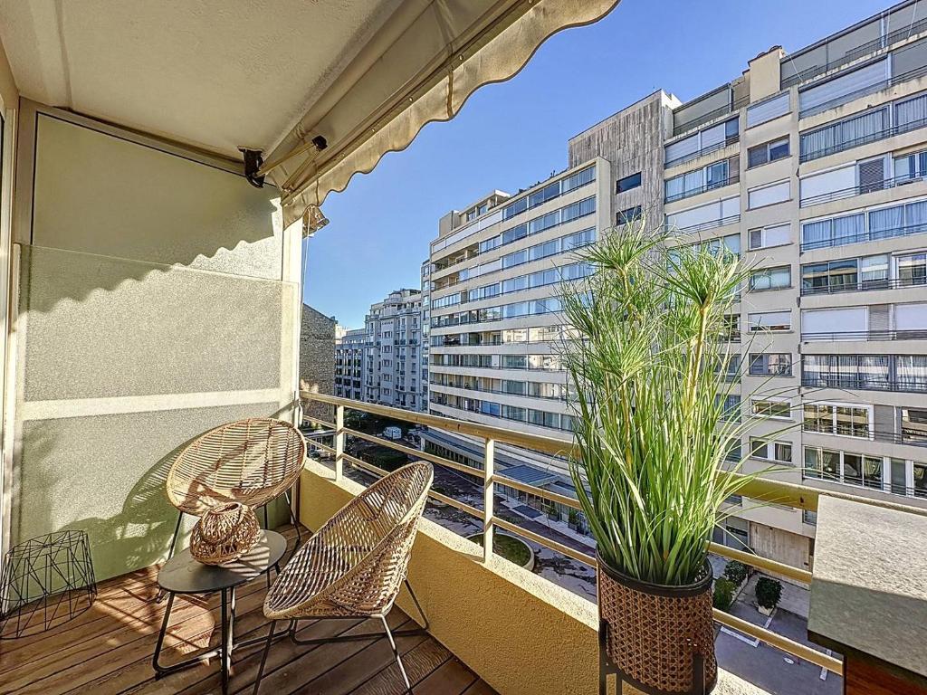 un balcón con 2 sillas y una mesa y algunos edificios en GHH406 - Résidences du Grand hôtel Studio avec terrasse en Cannes