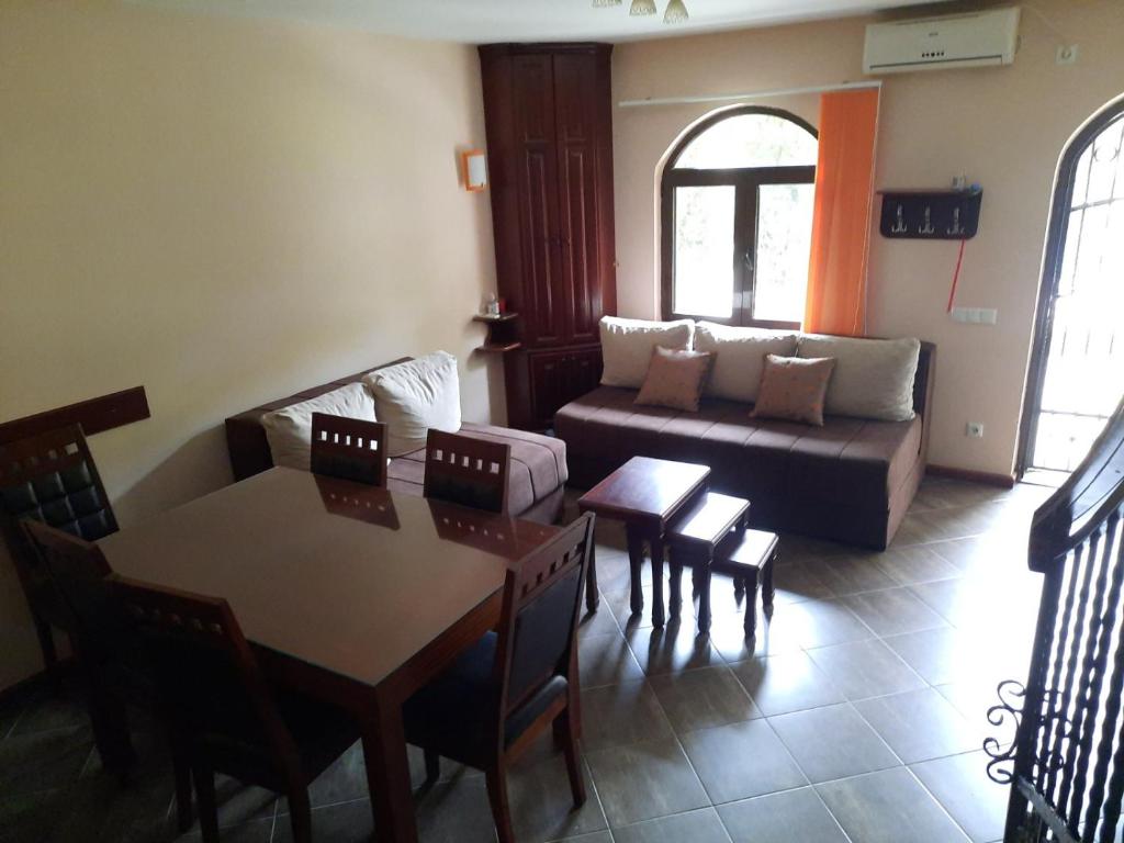 een woonkamer met een bank en een tafel en stoelen bij Apartman Aleksa in Bela Crkva