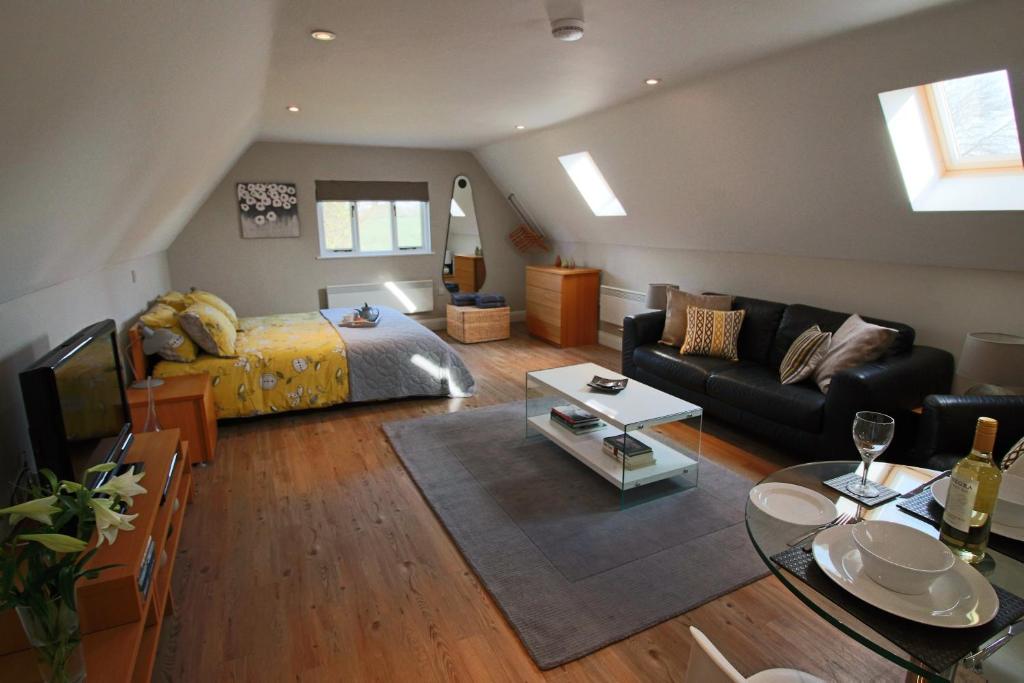 a living room with a bed and a couch at Little Wisteria in Canterbury