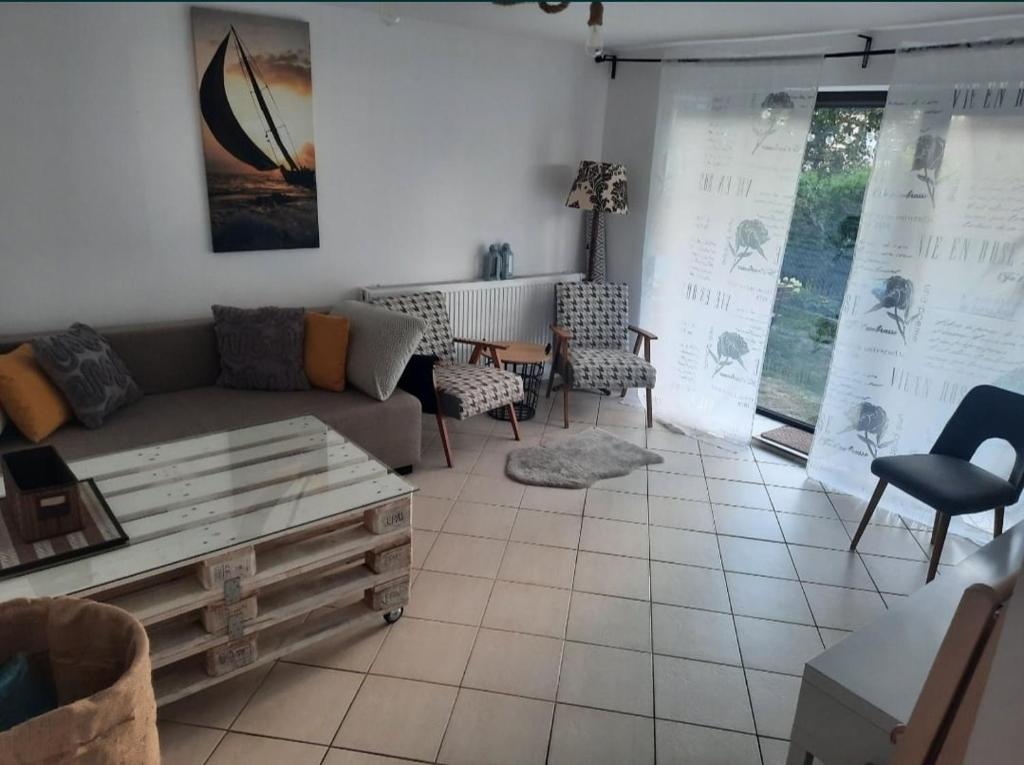 uma sala de estar com um sofá, uma mesa e cadeiras em Rodzinny dom wakacyjny 95 m2 nad jeziorem em Charzykowy