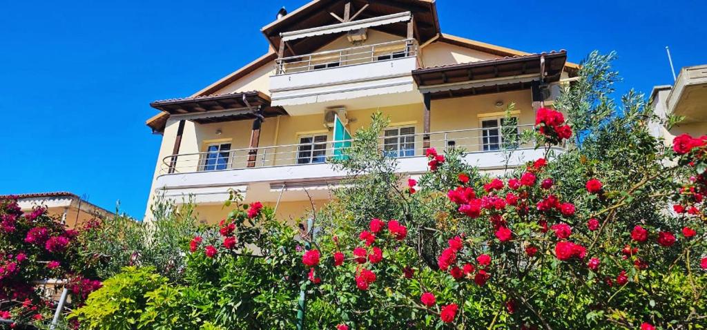 un edificio con flores rojas delante de él en Apartments Athina Orikum, en Orikum