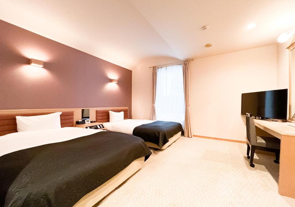 Habitación de hotel con 2 camas y TV de pantalla plana. en APA Hotel TKP Sapporo Eki-Kitaguchi Excellent en Sapporo