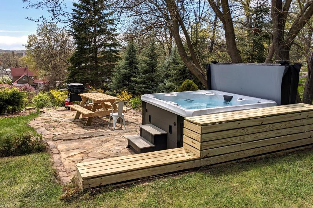 a hot tub on a deck with a picnic table at Balsam House in Baraboo