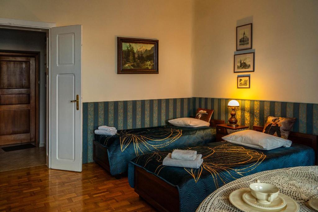 ein Hotelzimmer mit 2 Betten und einem Tisch in der Unterkunft Apartamenty na Starówce in Kalisz
