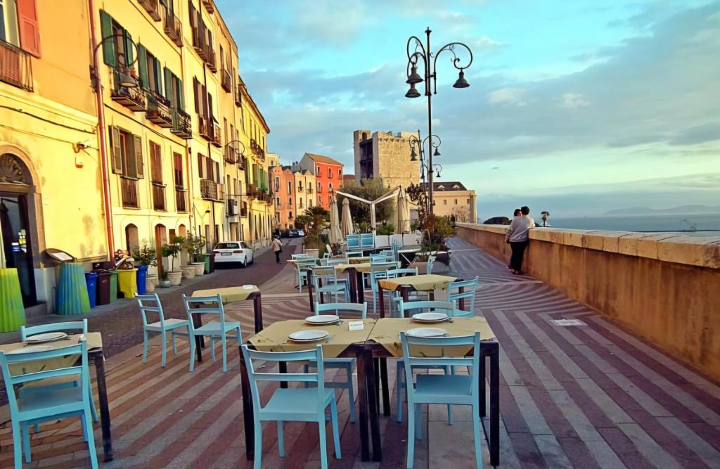 een rij tafels en stoelen in een stadsstraat bij La casa di Cry in Cagliari