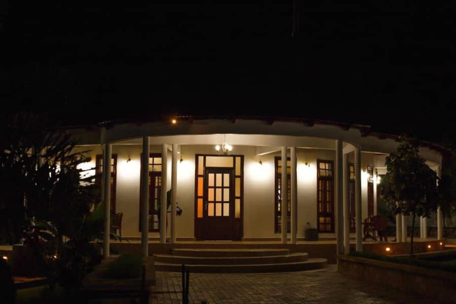 un edificio bianco con una porta di notte di Hellen's Riverside villas a Moshi