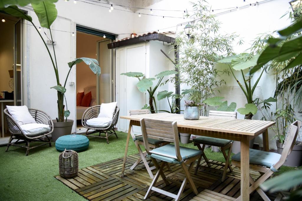 een terras met een houten tafel, stoelen en planten bij Jama Maison Garden in Napels