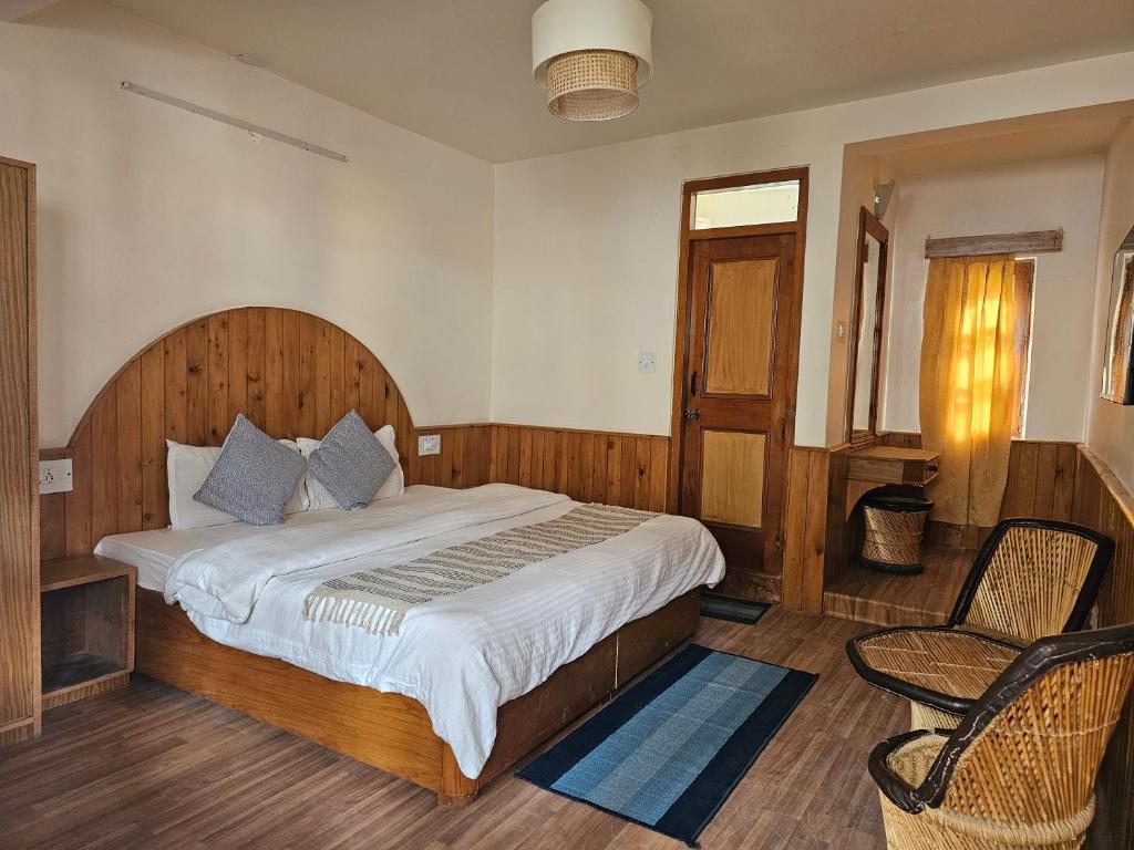 a bedroom with a large bed and a chair at Drifters Inn - The Hidden Tribe in Manāli