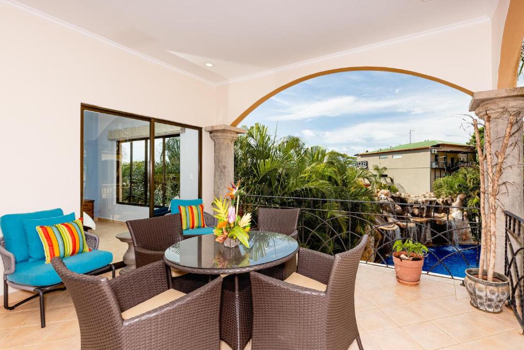 a patio with a table and chairs and a balcony at Sunrise 2 - 3 Bedroom Condo At Tamarindo in Tamarindo