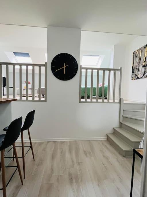 une chambre avec une horloge sur le mur et des chaises dans l'établissement Studio centre ville, à Bar-le-Duc