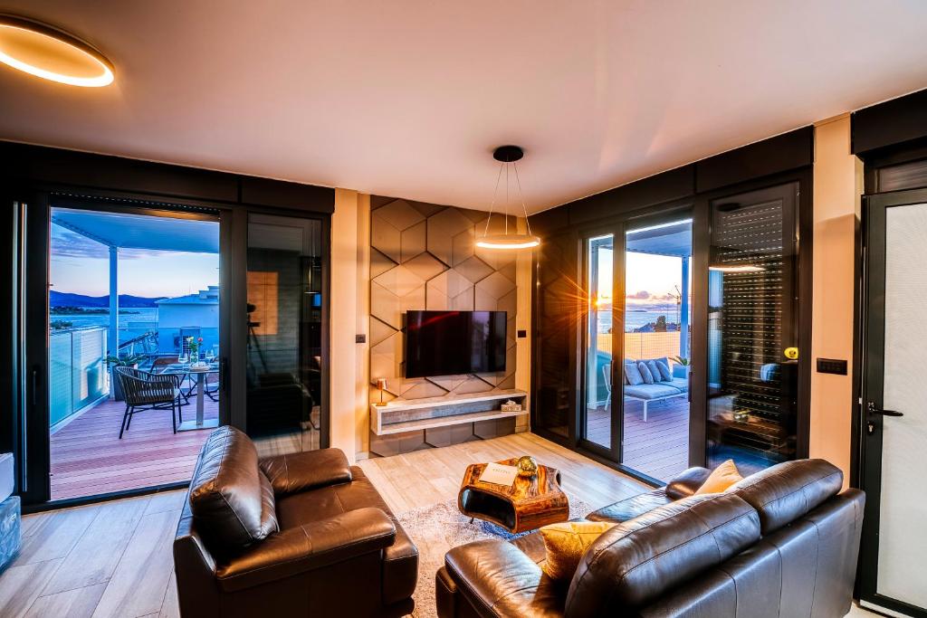 sala de estar con muebles de cuero y TV en Dedaj Resort - Villa Delux en Zadar