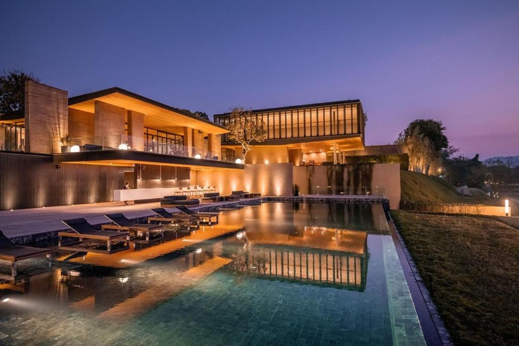 una casa con piscina por la noche en Tara Villa, en Kanchanaburi