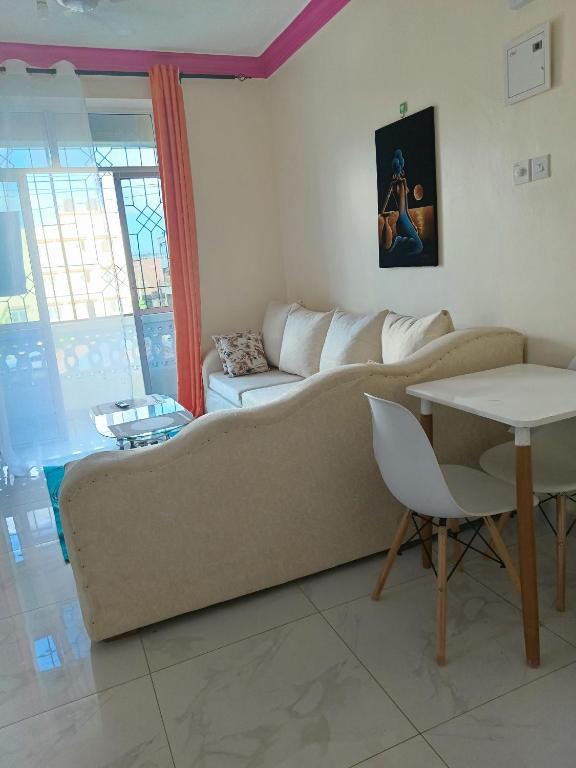 - un salon avec un canapé et une table dans l'établissement Royals apartment, à Mombasa