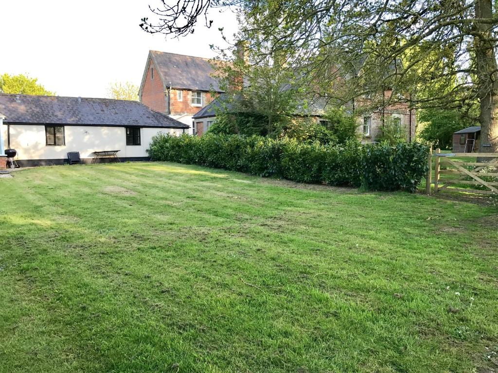 a yard in front of a house with a fence at Pond Cottage in Shaftesbury