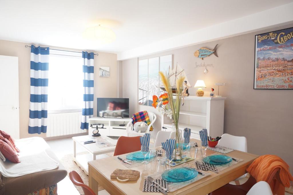 un salon avec une table et une salle à manger dans l'établissement Le 33 Cour Normande - Appartement 2 chambres - 2 à 4 personnes - coeur Cabourg, à Cabourg