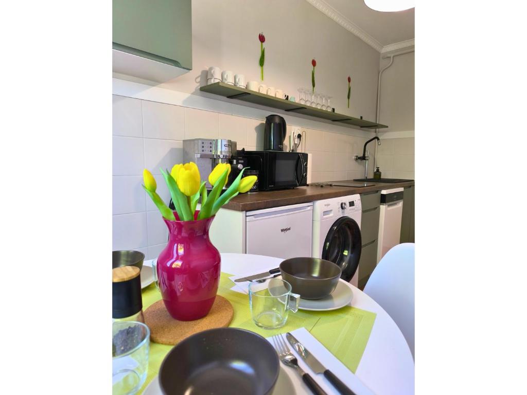 una cocina con un jarrón de flores sobre una mesa en Lokal 40 - apartament w samym centrum, en Rymanów-Zdrój