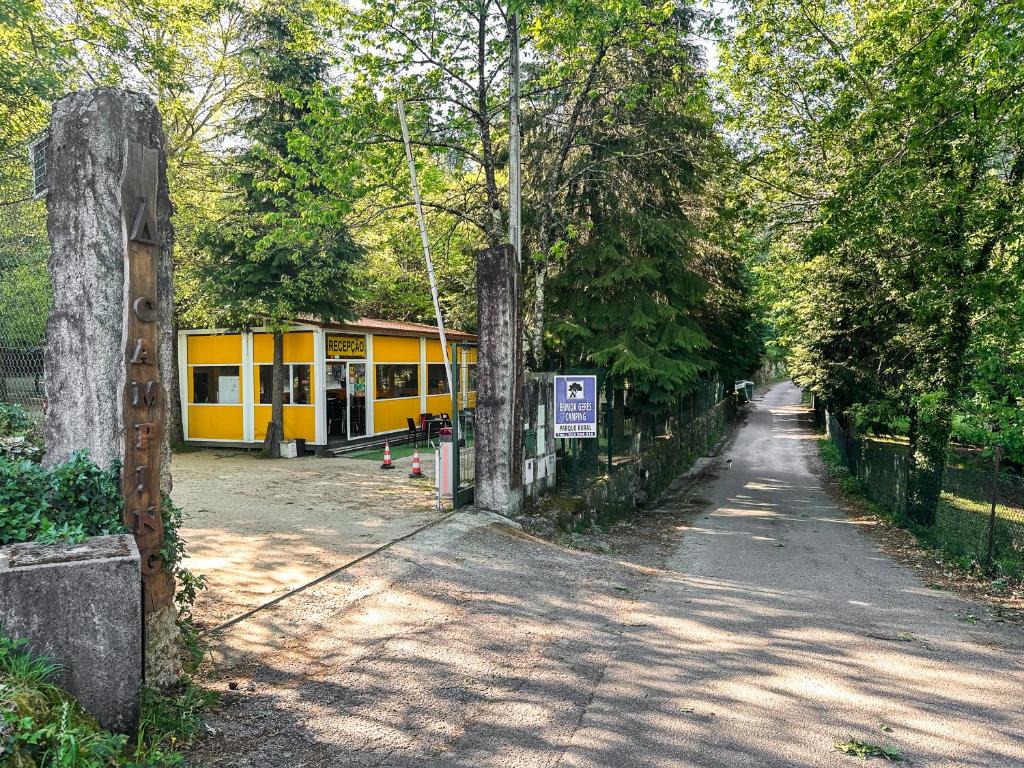 a street with a yellow building on the side of a road at Ermida Gerês Camping in Ermida