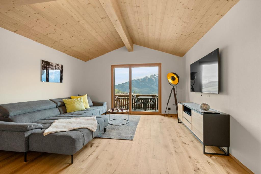 ein Wohnzimmer mit einem Sofa und einem TV in der Unterkunft Stilvolle 4.5 Zimmer Wohnung nahe der Talstation in Vella