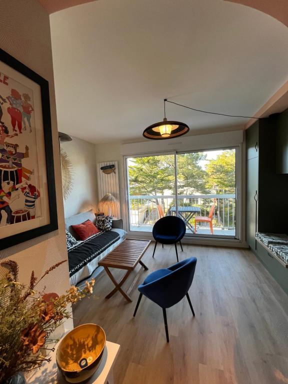 un salon avec une grande fenêtre et un canapé dans l'établissement Magnifique Studio lajarrige proximité plage et commerces, à La Baule