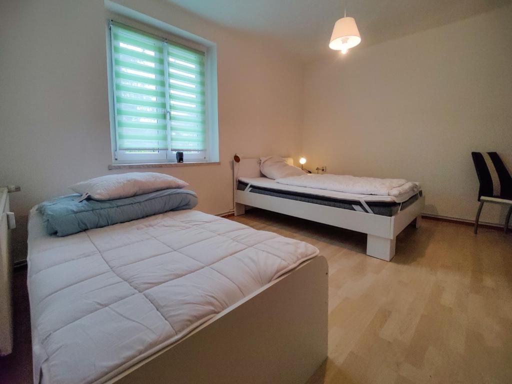 2 camas en una habitación con ventana en FEWO Jänschwalde II, en Jänschwalde Ost