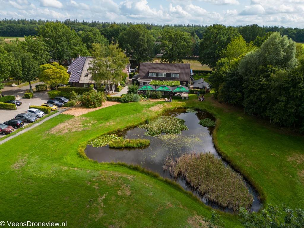 een luchtzicht op een golfbaan met een vijver bij Herberg de Loohoeve in Schoonloo
