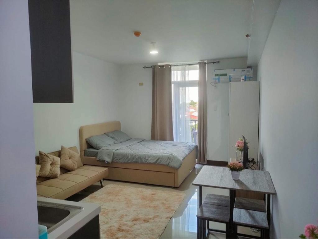 ein Wohnzimmer mit einem Bett und einem Sofa in der Unterkunft Saekyung 956 Condominium in Lo-oc