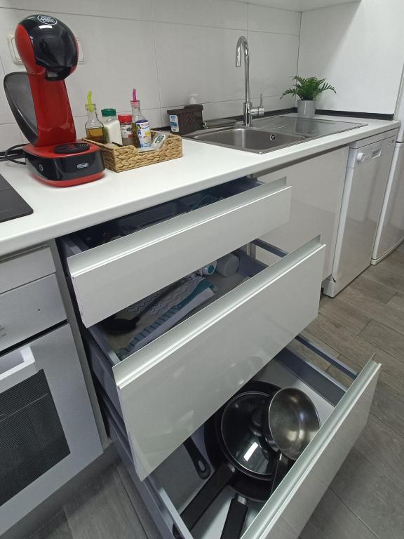 a kitchen with an open drawer with a pot at BEACH&GARDEN in Málaga