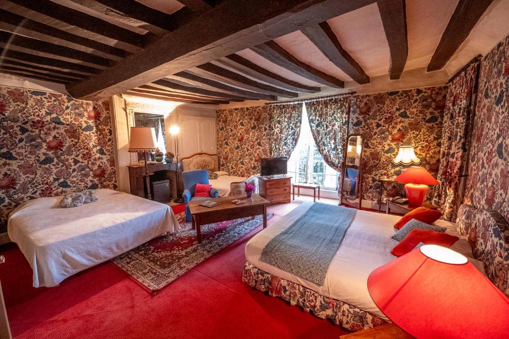 a bedroom with two beds and a table and chairs at Le Relais Cicero in La Flèche