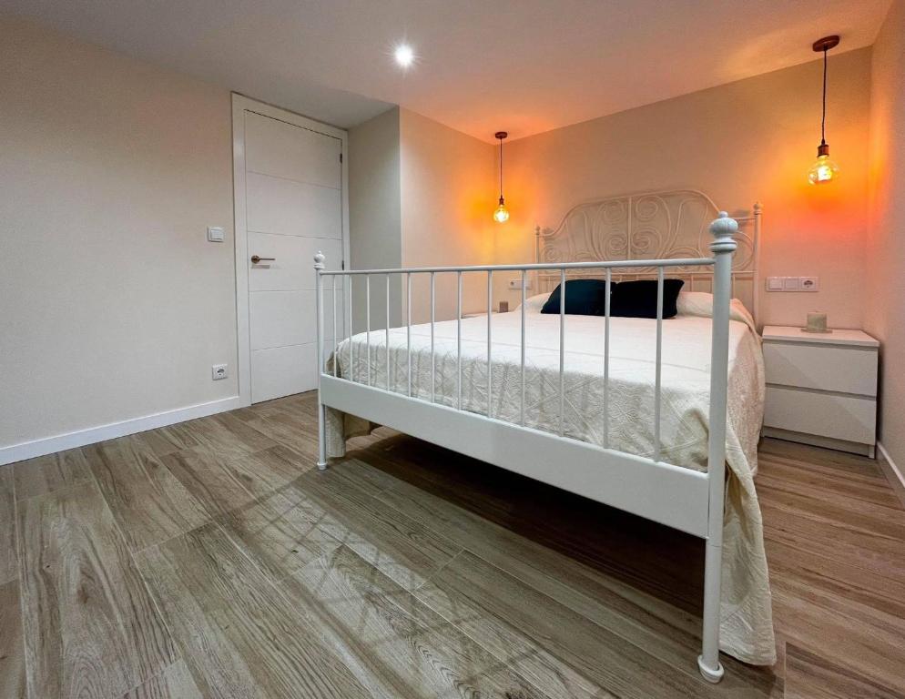 een slaapkamer met een wit bed in een kamer bij A casiña de Ana in Solleiros