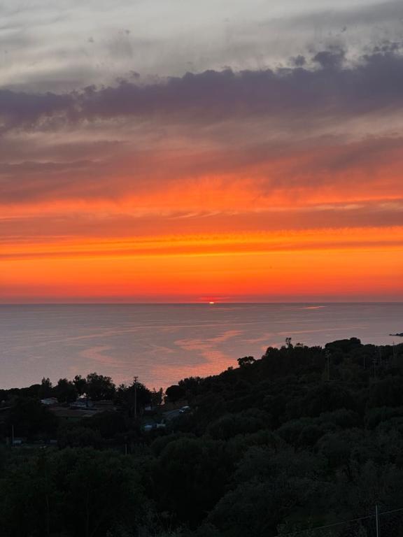 einen Sonnenuntergang über dem Meer von einem Hügel in der Unterkunft Dimora degli Ulivi in Caprioli