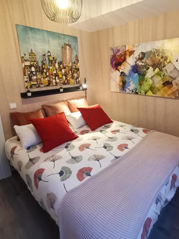 a bedroom with a large bed with red pillows at BEACH&GARDEN in Málaga