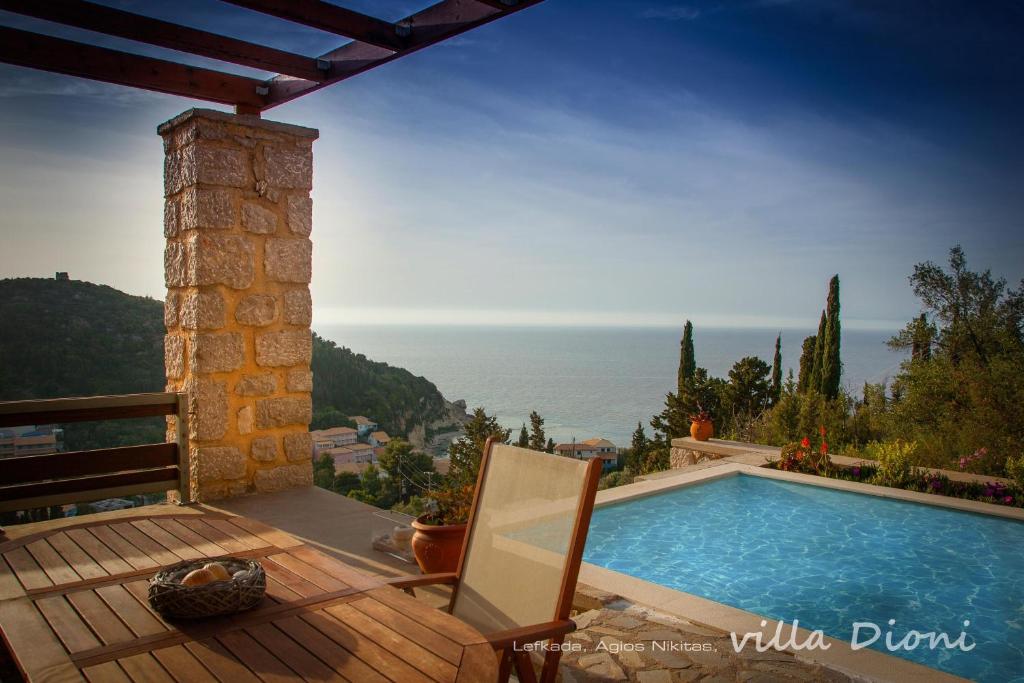 a villa with a swimming pool and a chair at Villa Dioni in Agios Nikitas