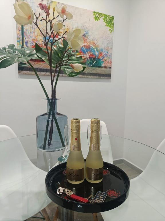 two champagne bottles on a tray on a table with a vase at BEACH&GARDEN in Málaga