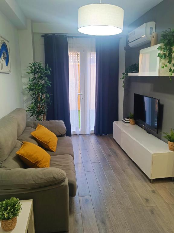 a living room with a couch and a flat screen tv at BEACH&GARDEN in Málaga