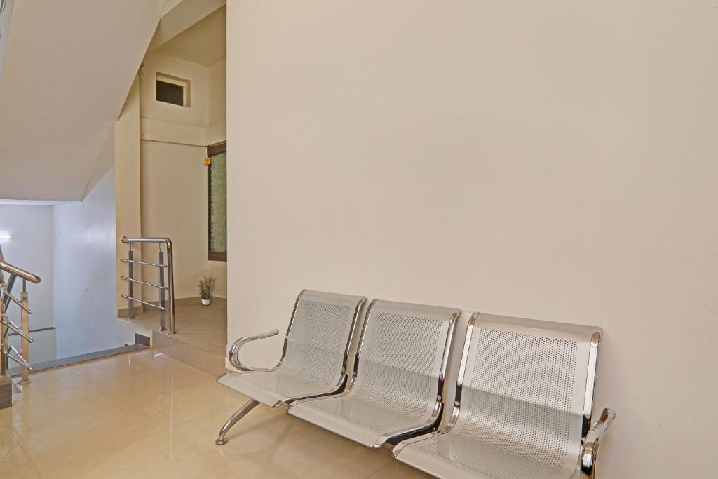 eine Reihe silberner Stühle in einem Zimmer mit einer Treppe in der Unterkunft OYO Flagship R V Palce in Gorakhpur